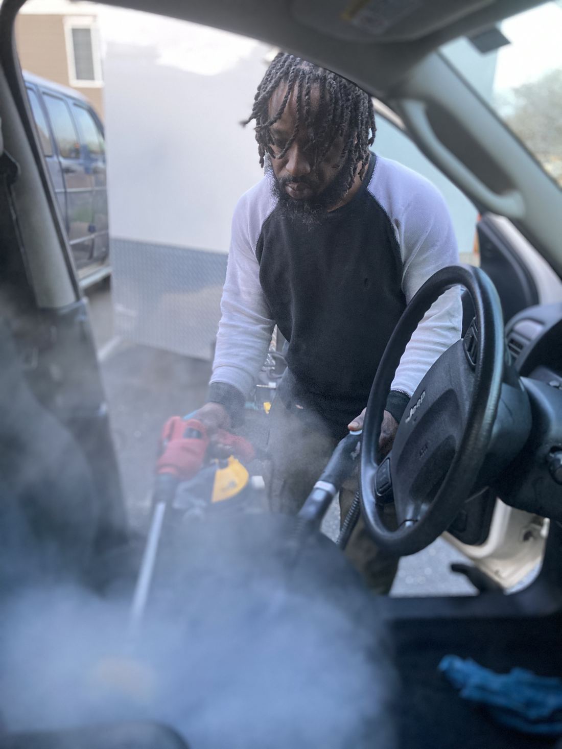 Steam cleaning a vehicle interior with professional-grade equipment.
