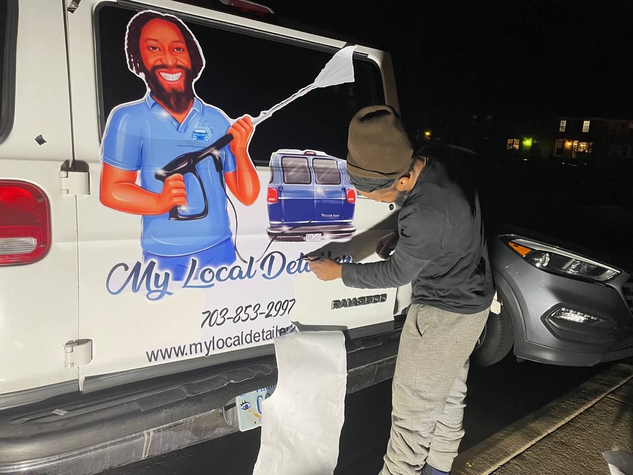 My Local Detailer team member working on a customer's vehicle next to the company van