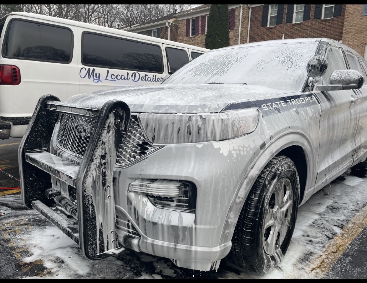 Deep foam wash on a police interceptor SUV reveals stunning detail and shine in residential driveway setting.